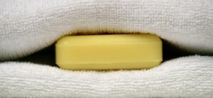 Saponetta posizionata sotto le lenzuola su un letto, simbolo di trucchi per migliorare il sonno.