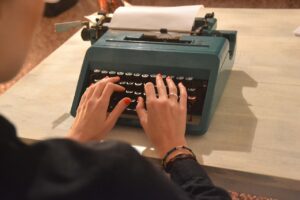 Macchina da scrivere Olivetti Lettera 22 su un tavolo, simbolo di design e storia della scrittura.